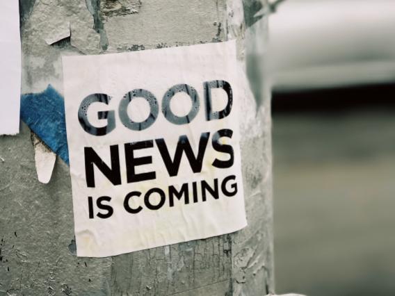 good news is coming flyer taped to a pole